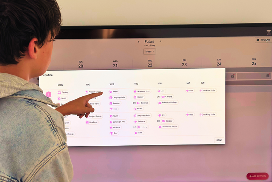 Boy pointing at Freely homeschool tracking app on a tv